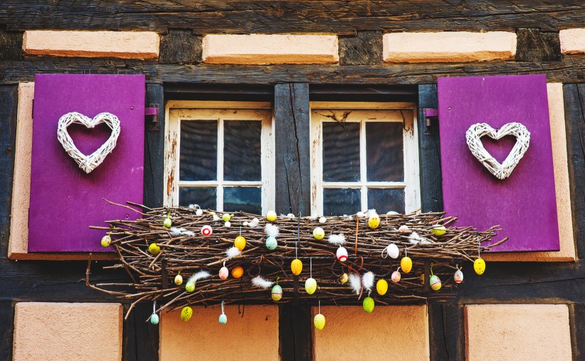 Cute window with hearts and traditional Easter decorations in european town